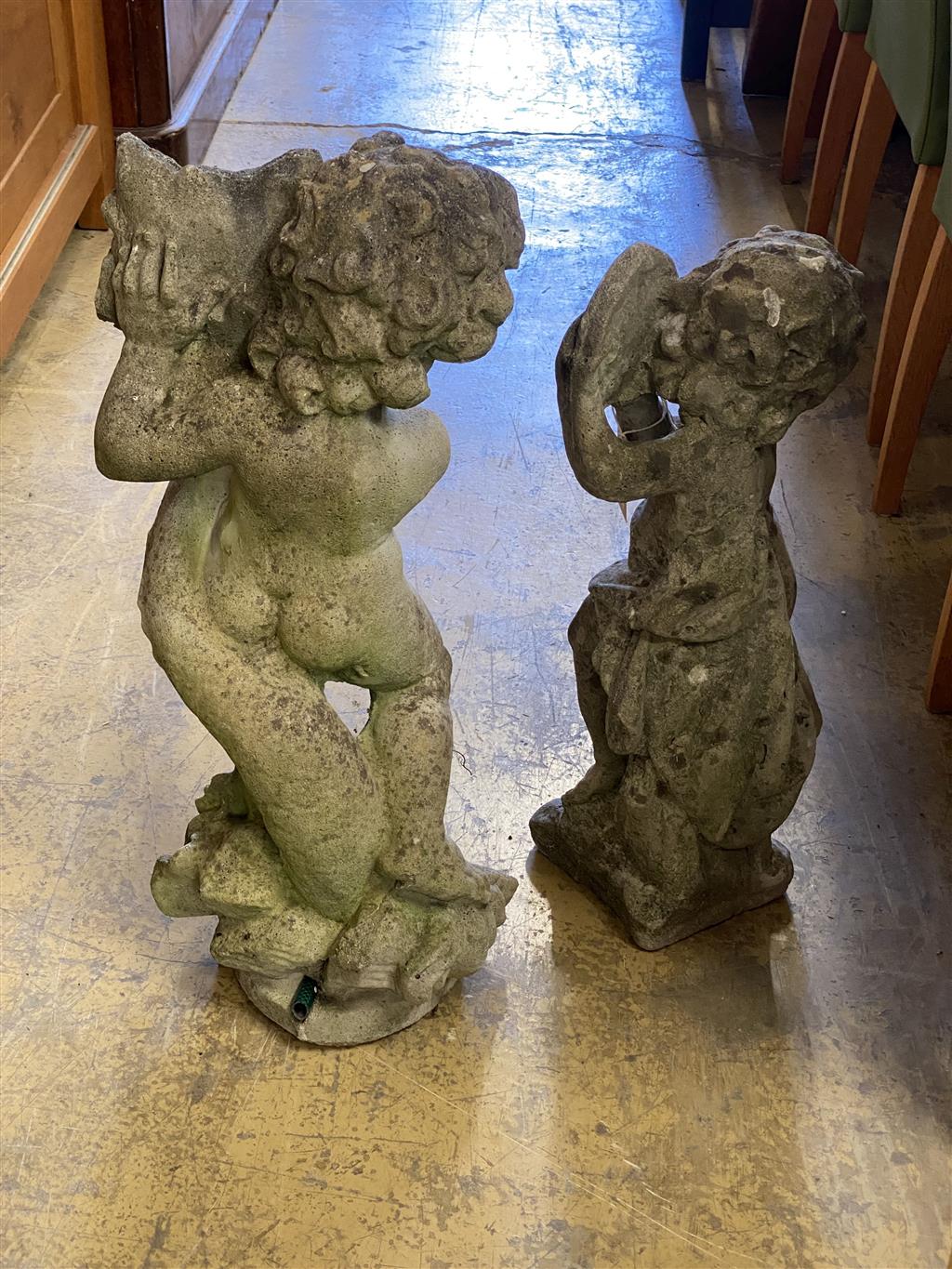 Two reconstituted stone garden cherub ornaments, larger 70cm high